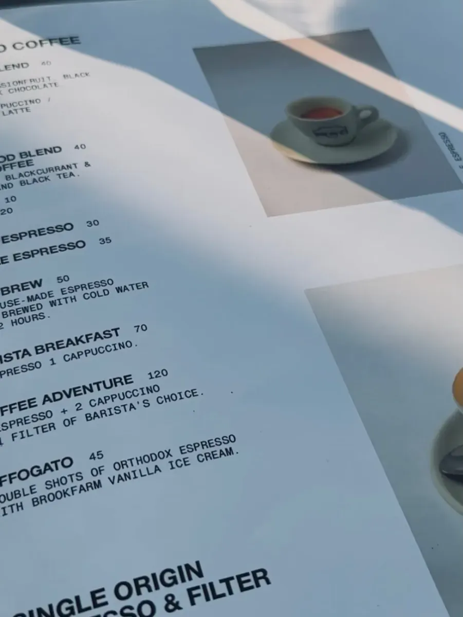 Printed coffee menu page with house blend, espresso, cold brew, and barista breakfast listings