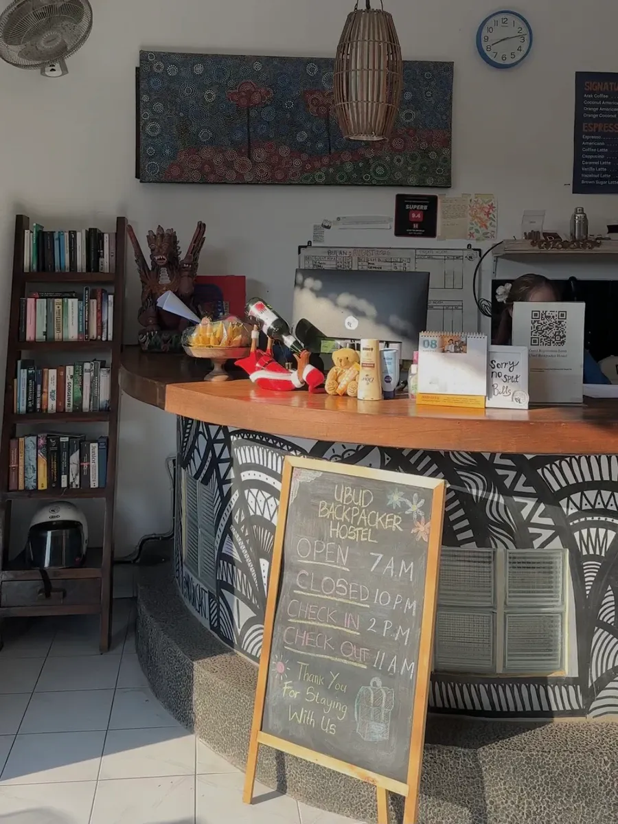 Reception desk with a chalkboard listing opening hours and check-in times