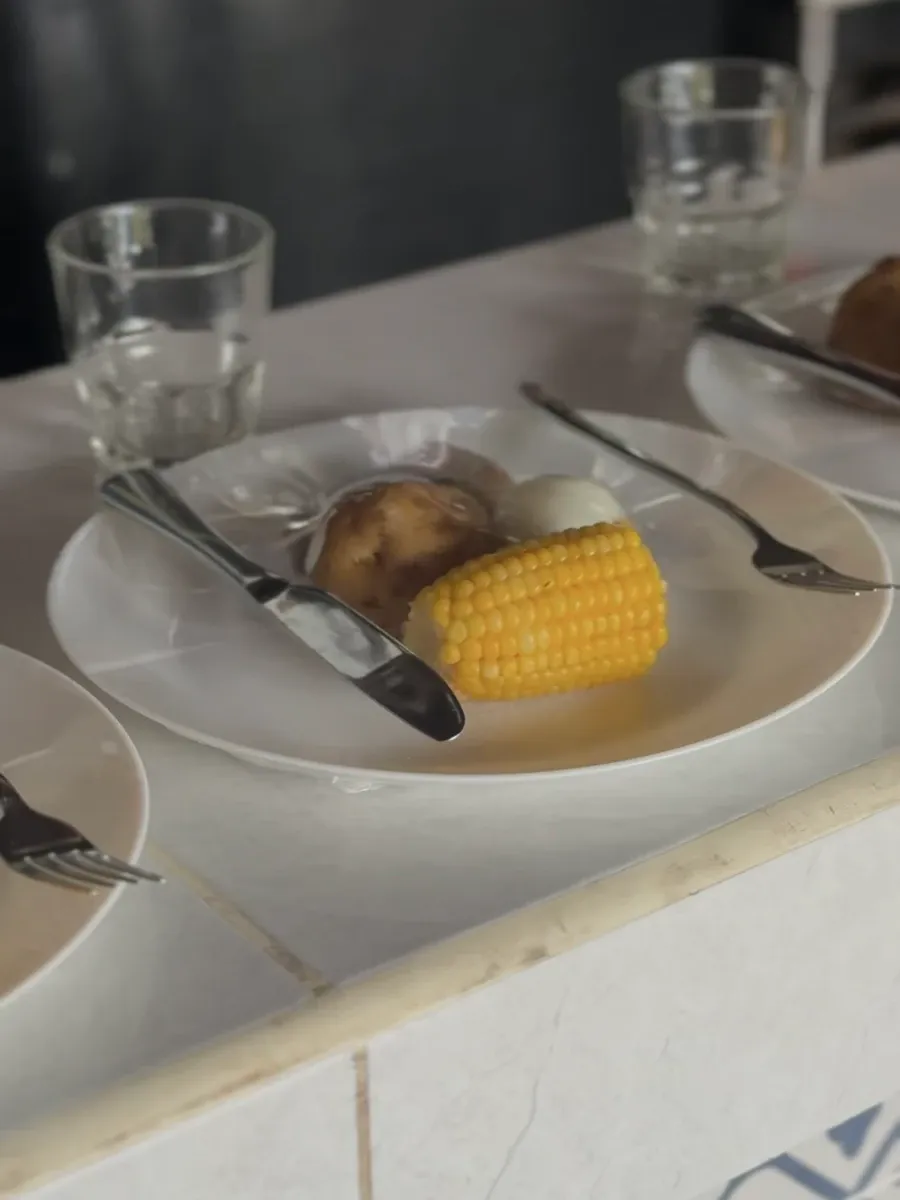 A simple breakfast of corn, potato and egg on a white plate
