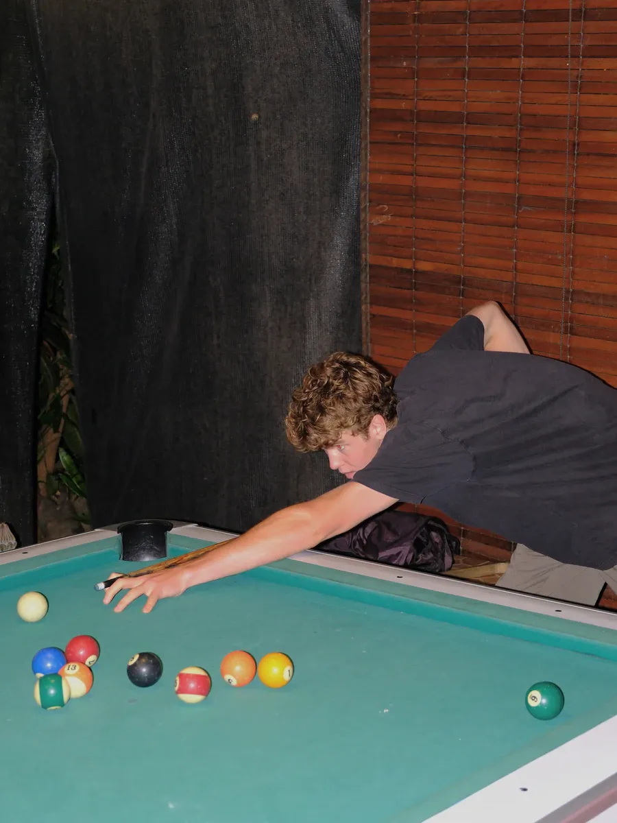 A guest lining up a shot on the pool table