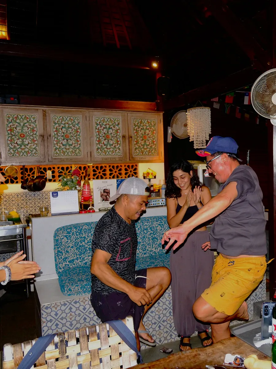 Guests dancing and laughing in the common room during an evening gathering